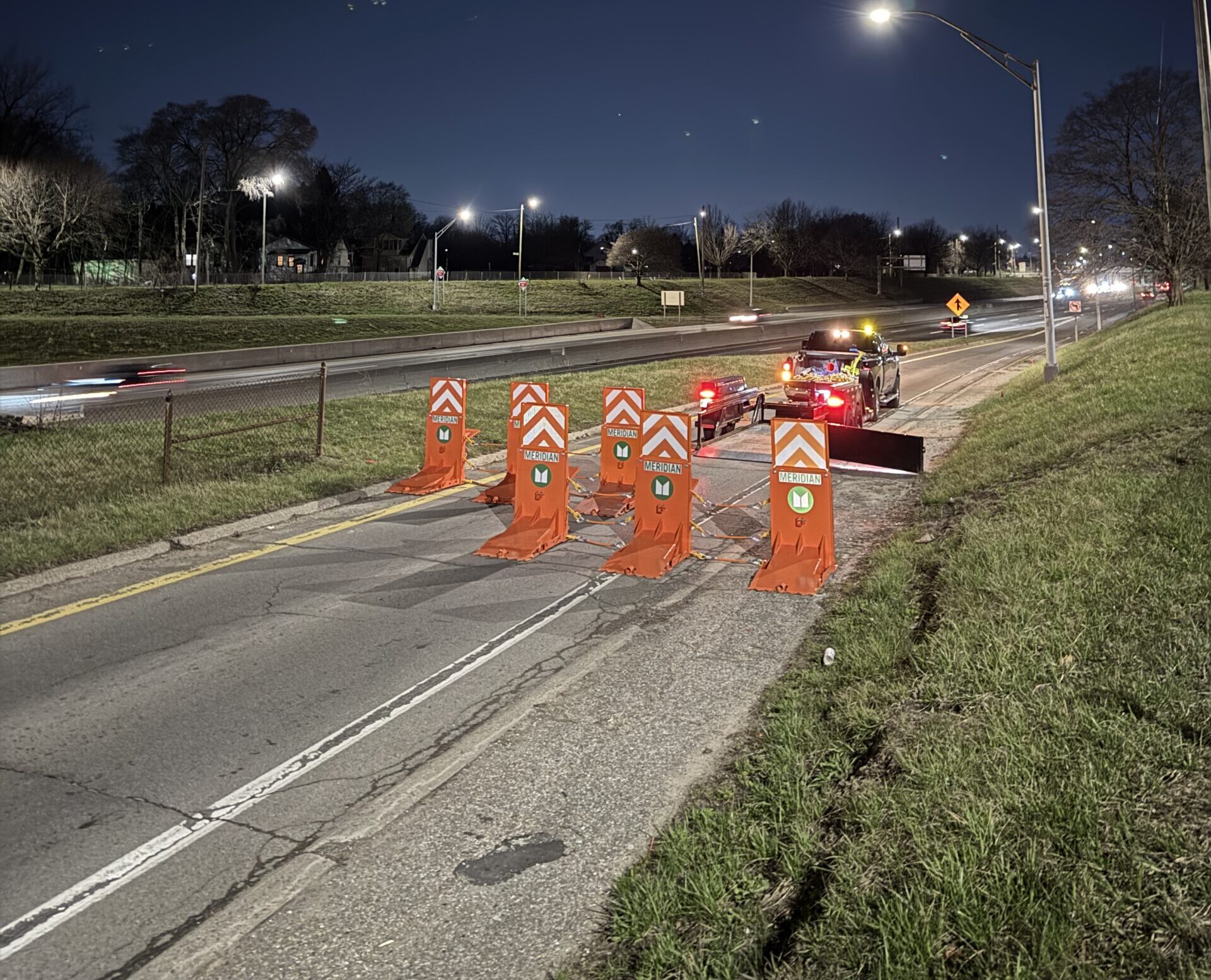 Archer guard protects a night crew on a highway on-ramp